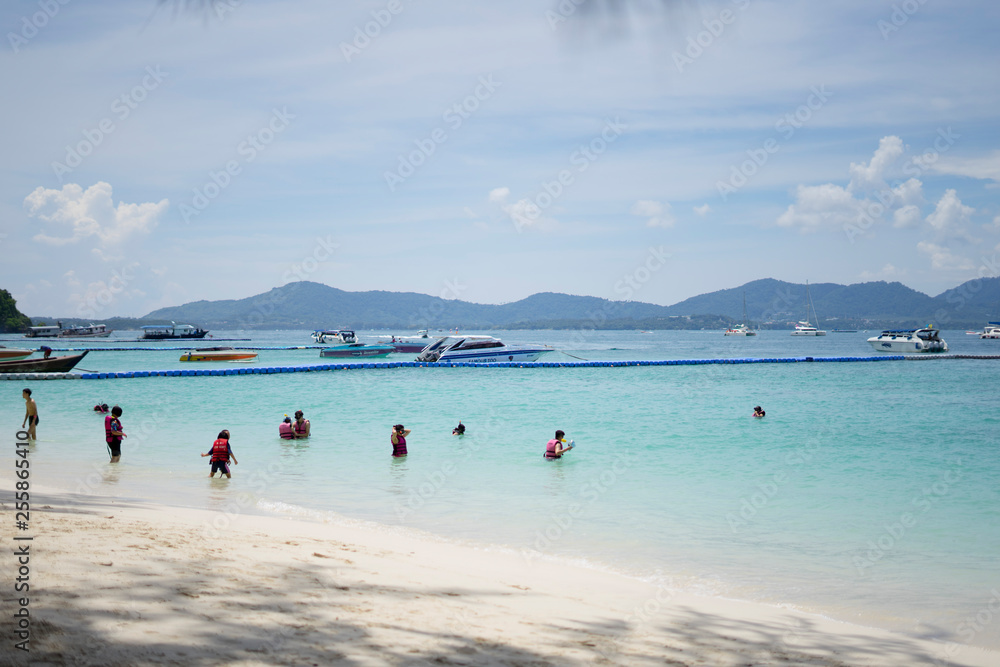 tourists walking along the beautiful beach of He island in Phuket,Thailand