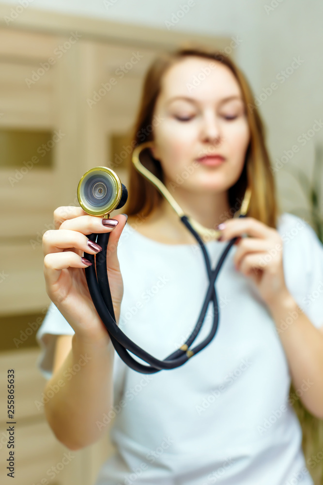 Close up portrait of doctor with stethoscope in ear. A female doctor with a stethoscope listening. Physician listening to empty space with stethoscope. Close up portrait of doctor with stethoscope in ear. A female doctor with a stethoscope listening. Physician listening to empty space with stethoscope.