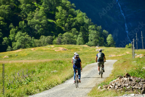 Fotografie people ride bicycle on mountain road at flam Norway