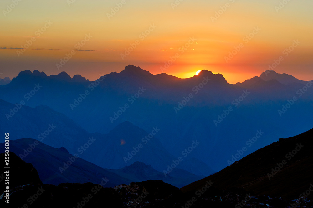 Obraz premium mountain silhouettes at the sunset, orange and red colors in the sky, Fann, Pamir Alay, Tajikistan