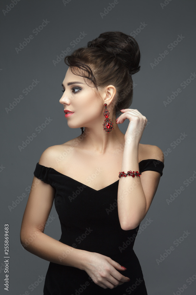 Fototapeta premium Gorgeous brunette in a black evening dress with jewels