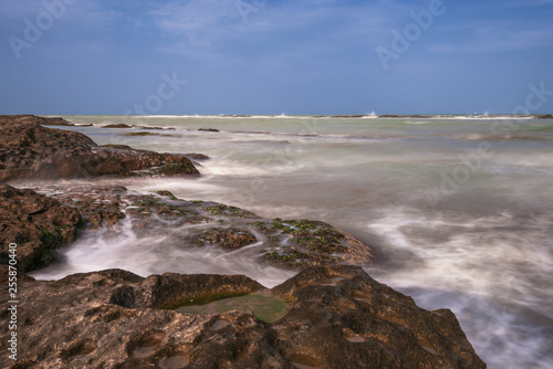 Colorful sea shore with green algae, long exposure water © Vastram