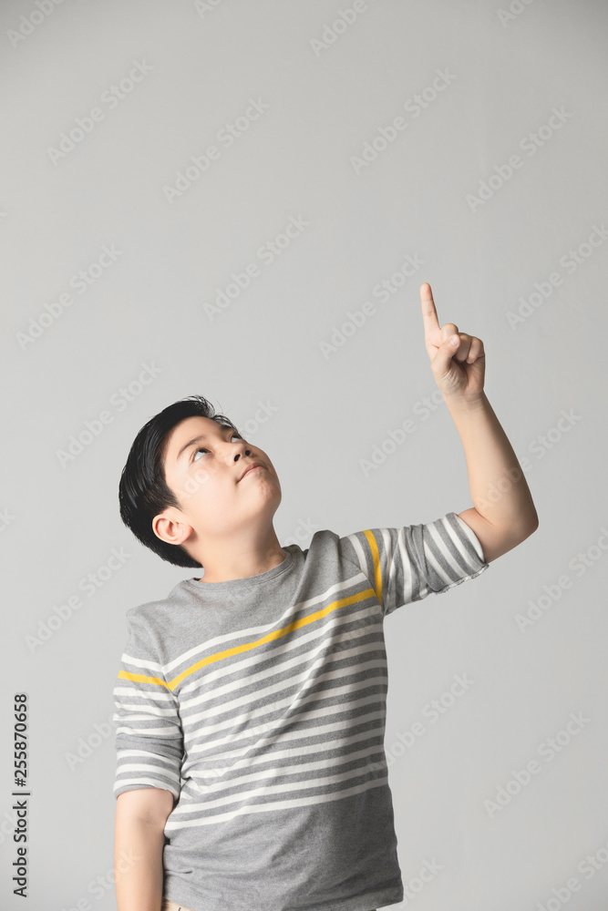 Asian preteen Teenage boy points up over gray background. Asian preteen Teenage boy points up over gray background.