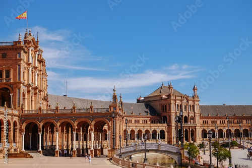 Fototapeta Naklejka Na Ścianę i Meble -  Tourists enjoy sightseeing around famous ancient landmark Plaza de España. Seville Spain.