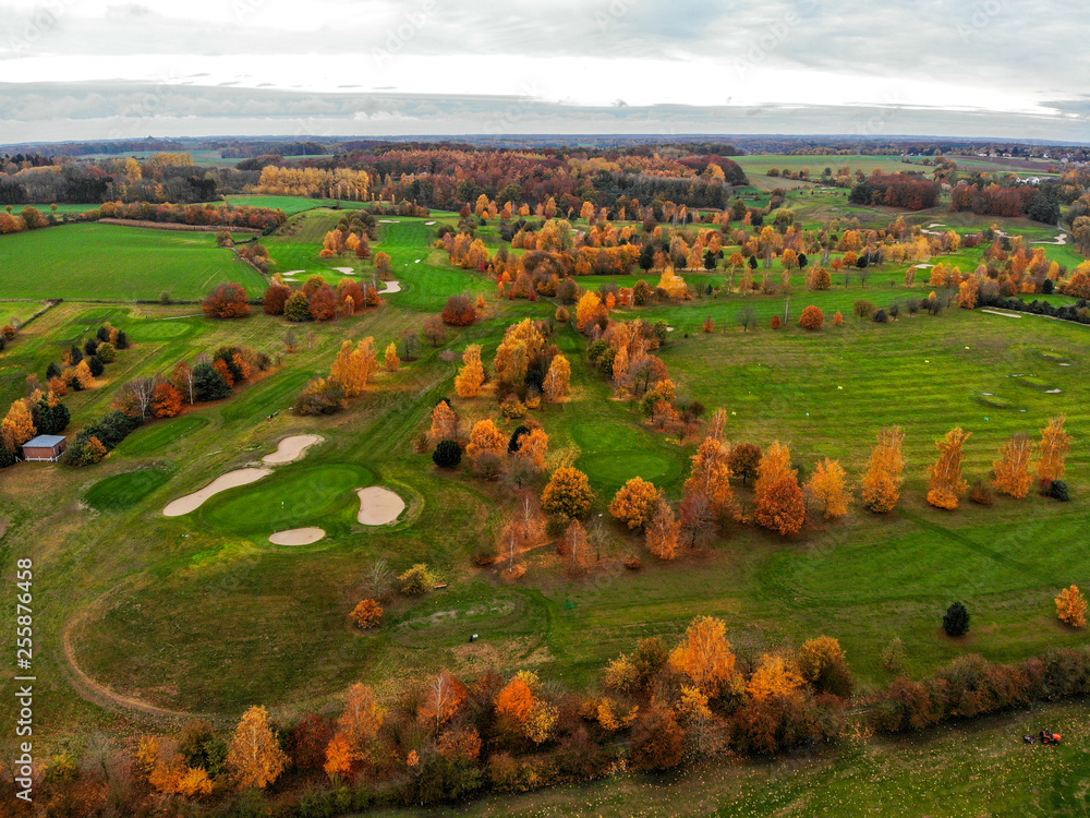 Aerial view of a golf course. Beautiful colorful trees and green course during autumn/winter season in the South of Belgium, Walloon Brabant.