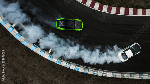 Two cars drifting battle on race track with smoke, Aerial view two car drifting battle.