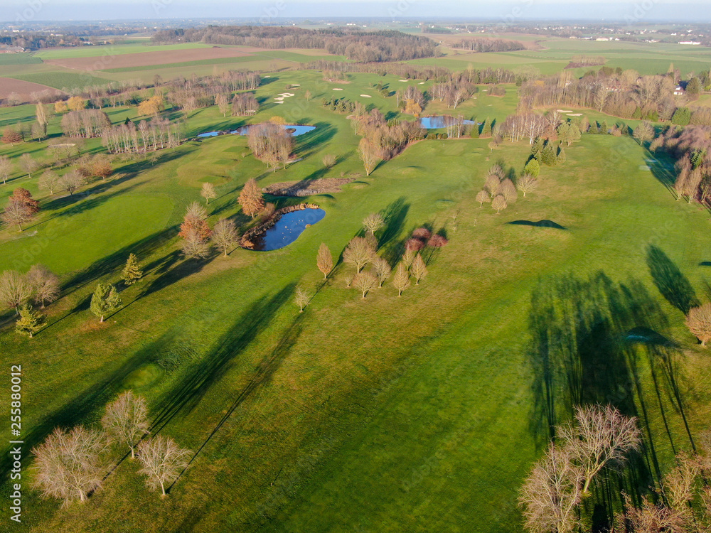 Aerial view of a golf course. Beautiful colorful trees and green course during autumn/winter season in the South of Belgium, Walloon Brabant.