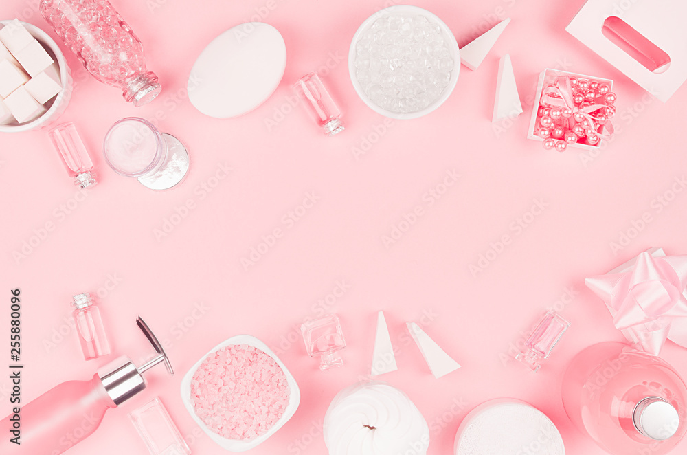 Cosmetic products for bathroom, health and hygiene in modern girlish style - soap, bath salt, oil, cream, perfume, pearls, gift box on pink as decorative border. Cosmetic products for bathroom, health and hygiene in modern girlish style - soap, bath salt, oil, cream, perfume, pearls, gift box on pink as decorative border.
