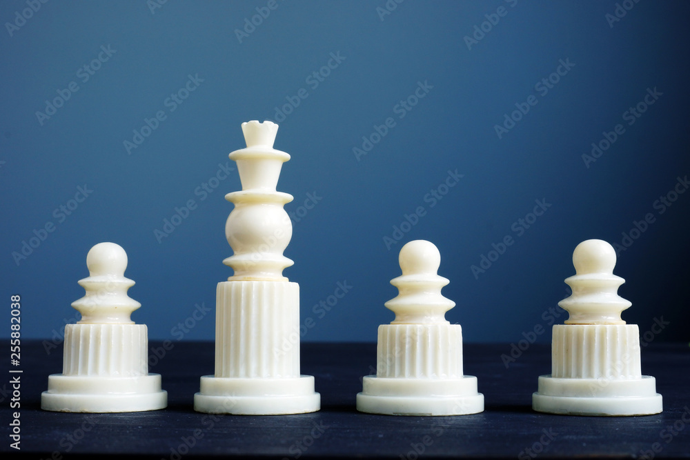Performance review concept. Pawns and king on a desk. Performance review concept. Pawns and king on a desk.