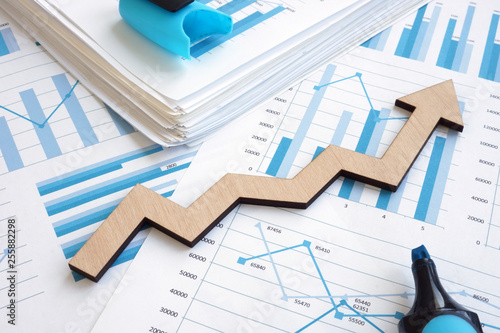 Fototapeta Business growth concept. Financial report with graphs and arrow.