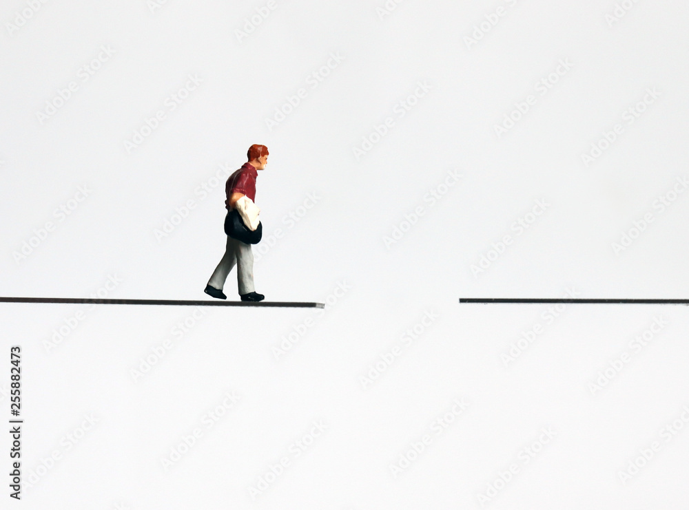 Obraz premium A miniature man walking with a bag.