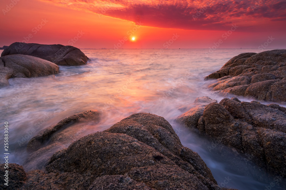 Beautiful natural seascape wave hit the rock during sunset