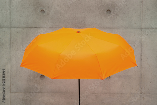 an umbrella in front of a concrete wall