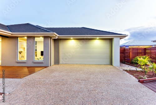 Garage with a long and wide concrete or stone yard in front at dawn or sundown © JRstock