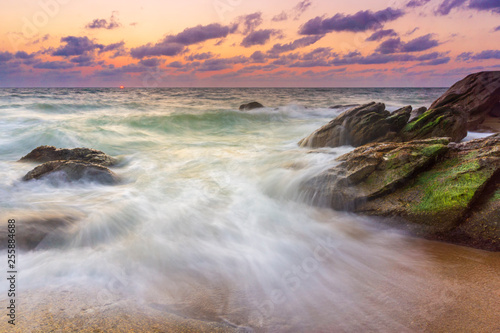 Beautiful natural seascape wave hit the rock during sunset
