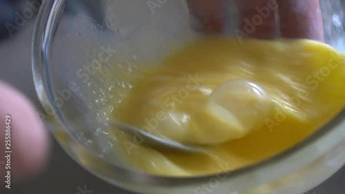 Slow motion footage. Chef preparing homemade omelette, mixing eggs with fork.