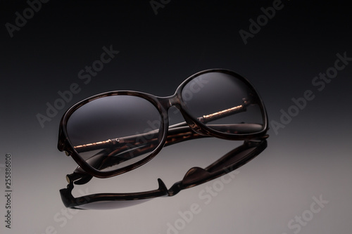 Elegant sunglasses on a dark background. Seasonal concept