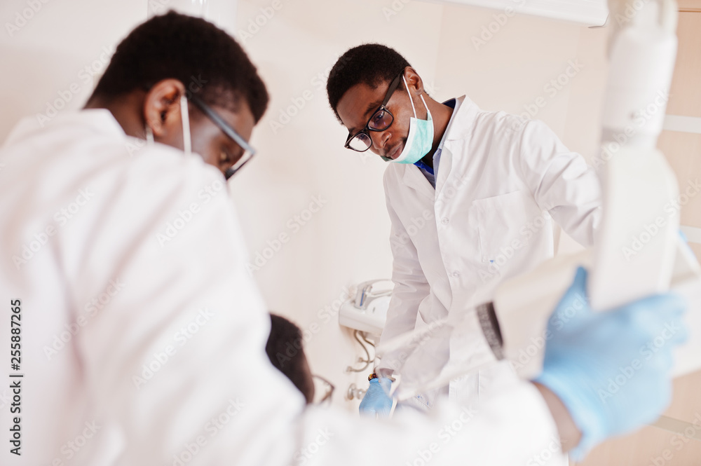 African american male doctors in professional uniform taking x-ray of patient. African american male doctors in professional uniform taking x-ray of patient.