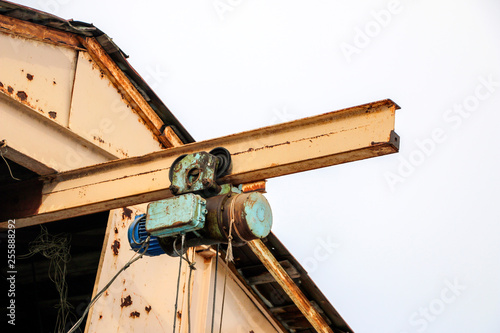 Obraz na plátně old girder crane with large iron hook lifts  heavy load on  slings