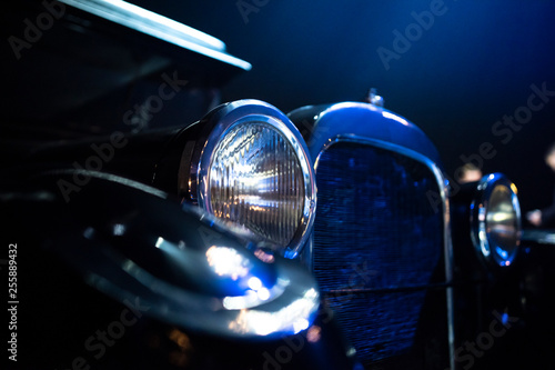 closeup of an old collectible classic car headlight with chrome details photo