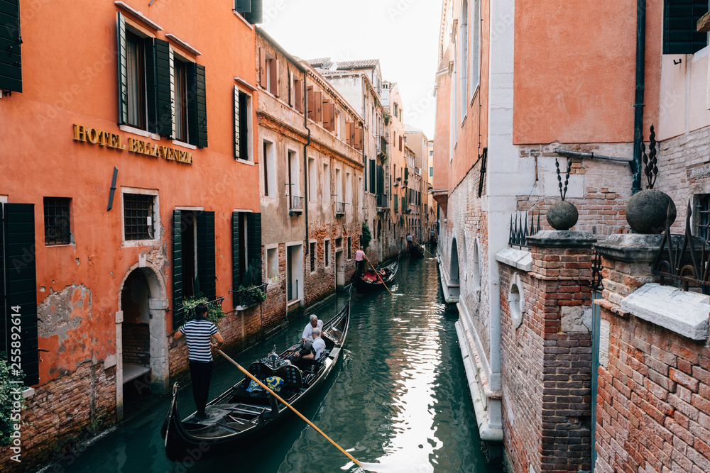 Panoramic view of Venice narrow canal with historical buildings and gondolas