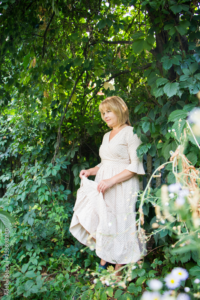 Portrait of beautiful blonde woman in summer garden