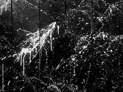 white splash ink paint on balck panel wood wall backgorund.