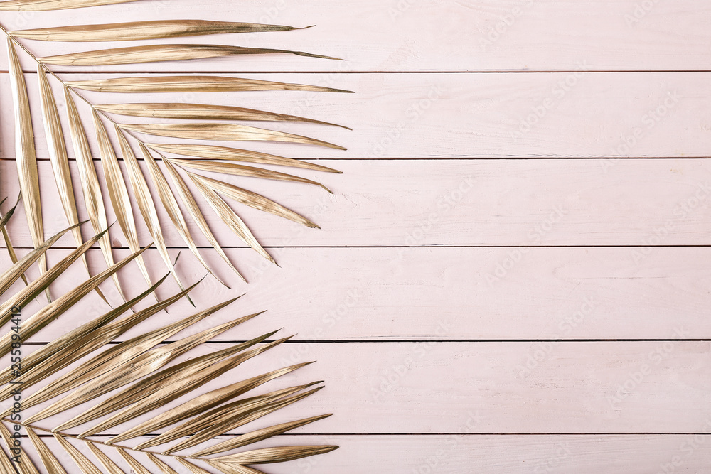 Obraz premium Painted golden tropical leaves on wooden background