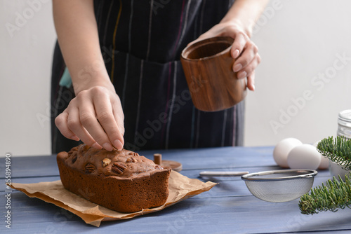 Woman decorating tasty homemade cake, closeup