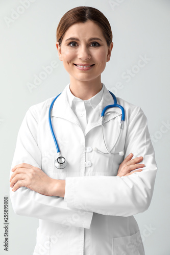 Beautiful female doctor on light background