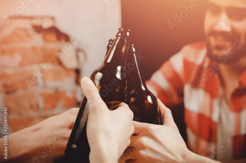 Boys in men beer bar ring bottles hand close up. Concept meeting, oration photo