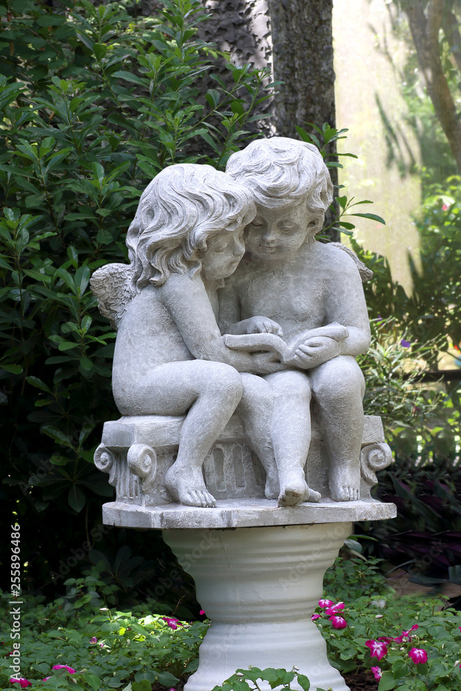 Little cupid statue isolated in the garden