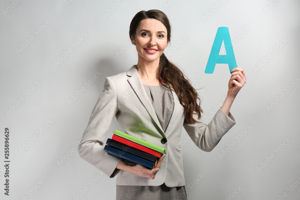 Female teacher on grey background