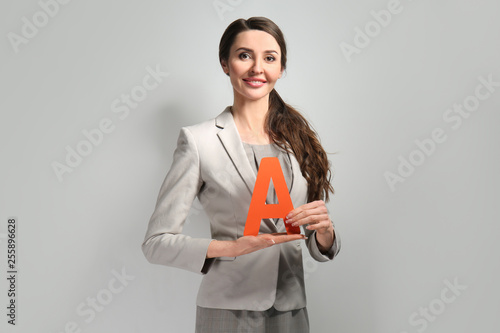 Female teacher on grey back...
