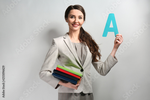 Female teacher on grey back...