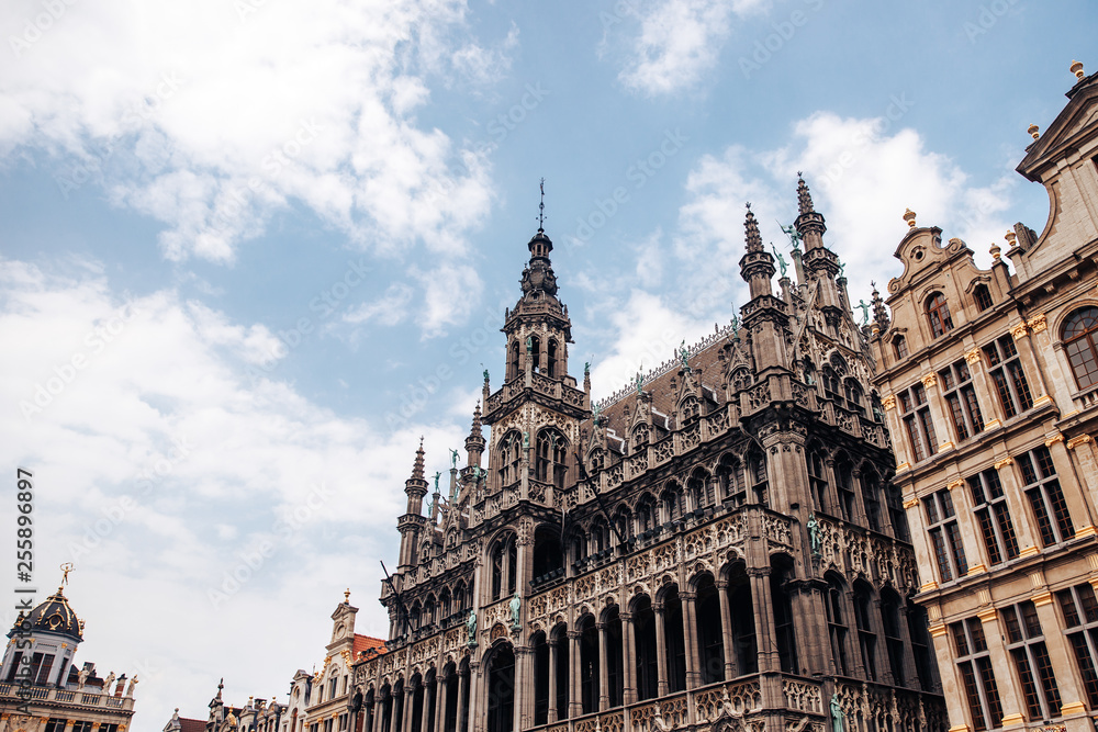 Monument of architecture against blue sky, bell tower, Gothic building bread house, Palace king, Museum keeps statue Manneken Pis.