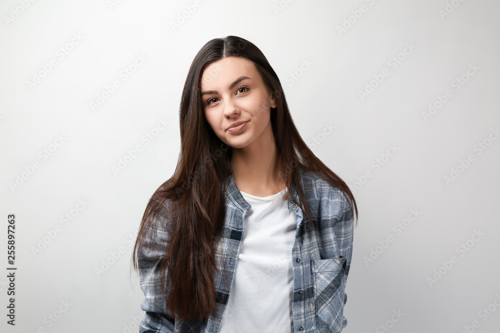 Portrait of beautiful woman in casual clothes on light background Portrait of beautiful woman in casual clothes on light background