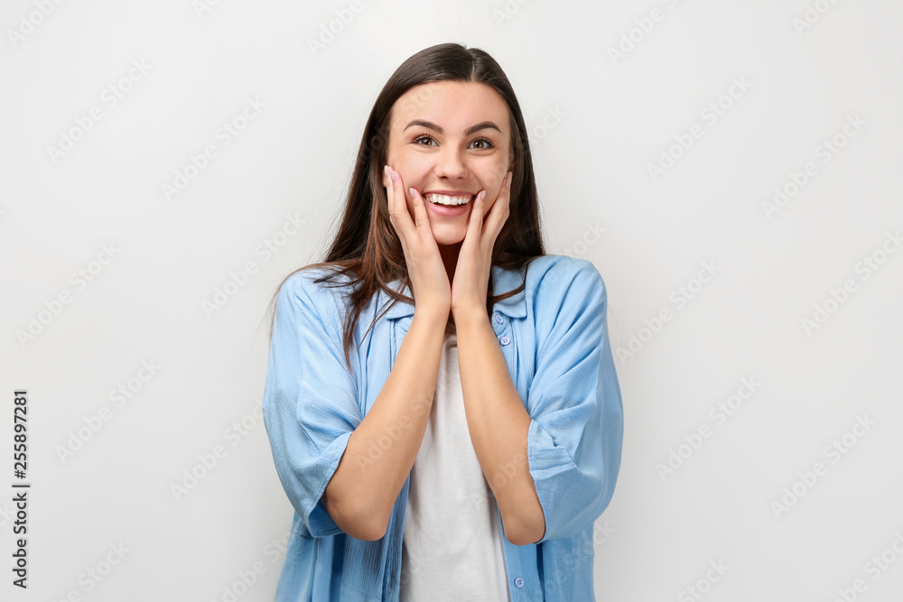 Portrait of beautiful surprised woman in casual clothes on light background Portrait of beautiful surprised woman in casual clothes on light background