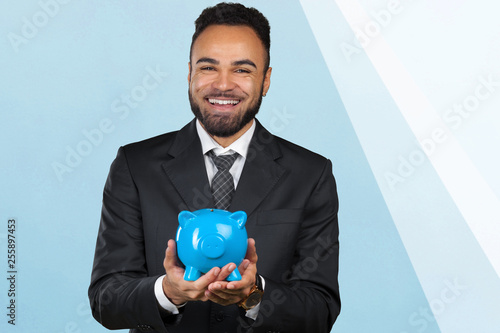 African American business man holding a piggy bank