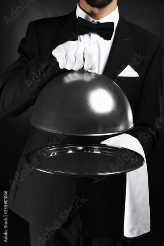 Handsome waiter with tray a...