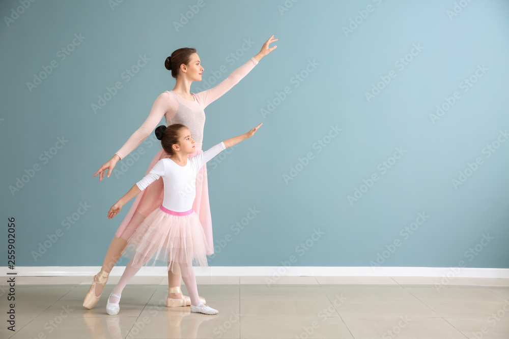 Little ballerina with coach against color wall Little ballerina with coach against color wall