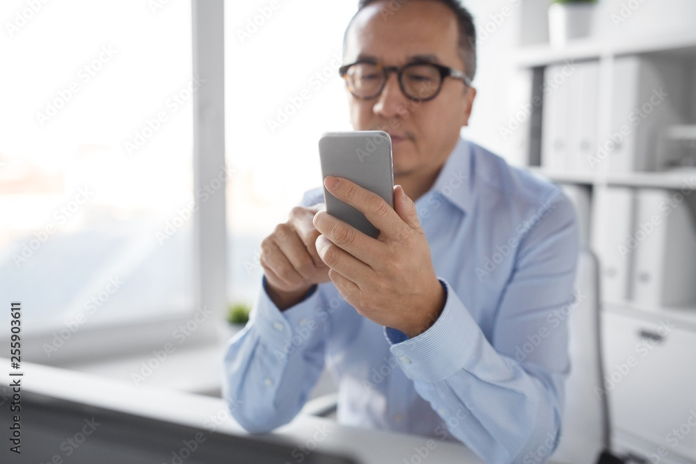 business, communication and technology concept - businessman using smartphone at office business, communication and technology concept - businessman using smartphone at office