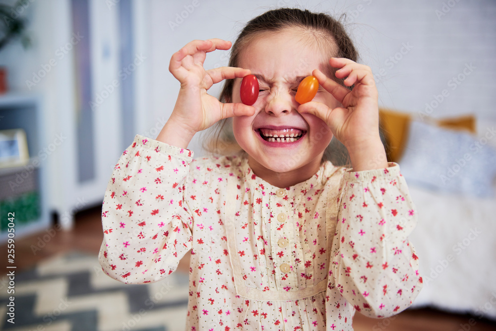 Girl holding tomatoes in front of her eyes Stock-Foto | Adobe Stock