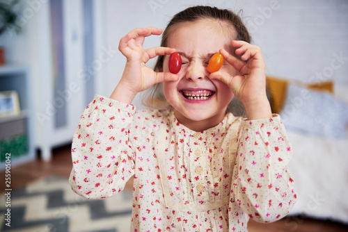 Girl holding tomatoes in front of her eyes