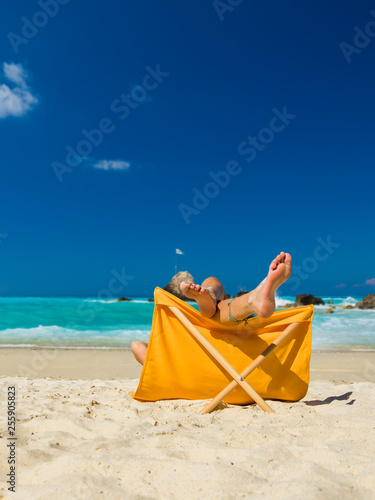 Fototapeta Naklejka Na Ścianę i Meble -  Woman enjoying her holidays on a transat at the tropical beach