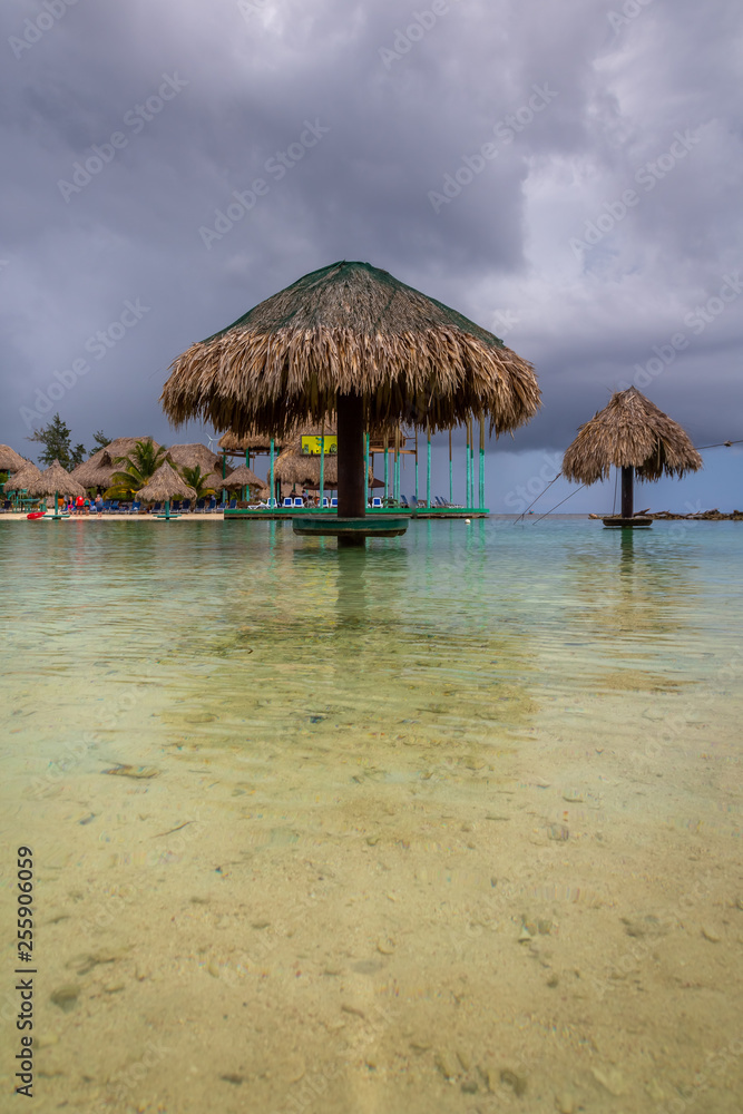 Palapa on the water by the beach. Typical Palapa in the beach of Roatan, Honduras. Exposure done during a cloudy day, with its beautiful and warm water.