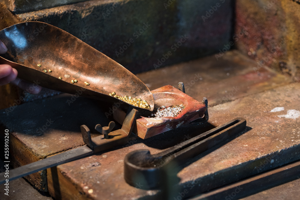 gold and silver granules in a crucible for melting an alloy, jewelry tools in a goldsmith workplace, copy space gold and silver granules in a crucible for melting an alloy, jewelry tools in a goldsmith workplace, copy space