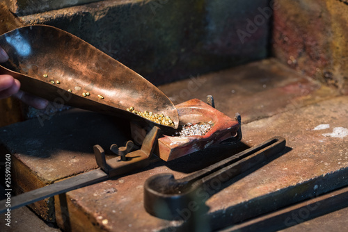 Fototapete gold and silver granules in a  crucible for melting an alloy, jewelry tools in a