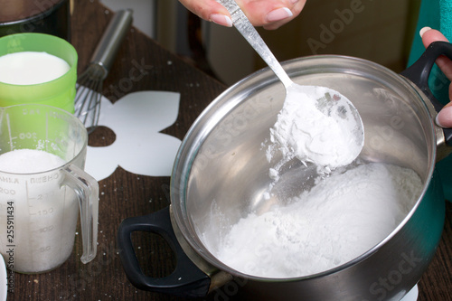 Cooking milk jelly. Cooking a cake of biscuit crumbs and milk jelly. On the surface of the table are the ingredients and cooking utensils.
