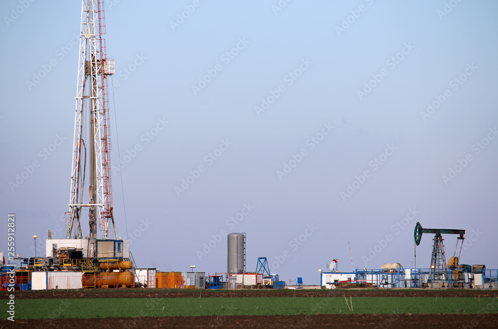 Oil and gas drilling rig and pump jack in oilfield mining industry Oil and gas drilling rig and pump jack in oilfield mining industry